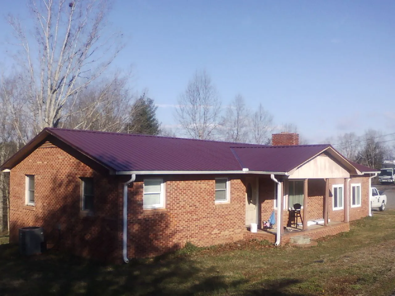 Burgundy metal roof on a brick ranch home with a new addition in Imperial