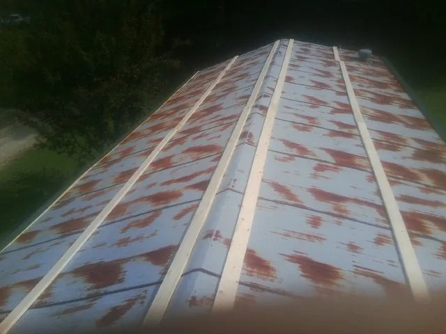 Rusted metal roof panels with new wood purlins before replacement — Storm Damage Roof Repair in Imperial by Roofing Brothers