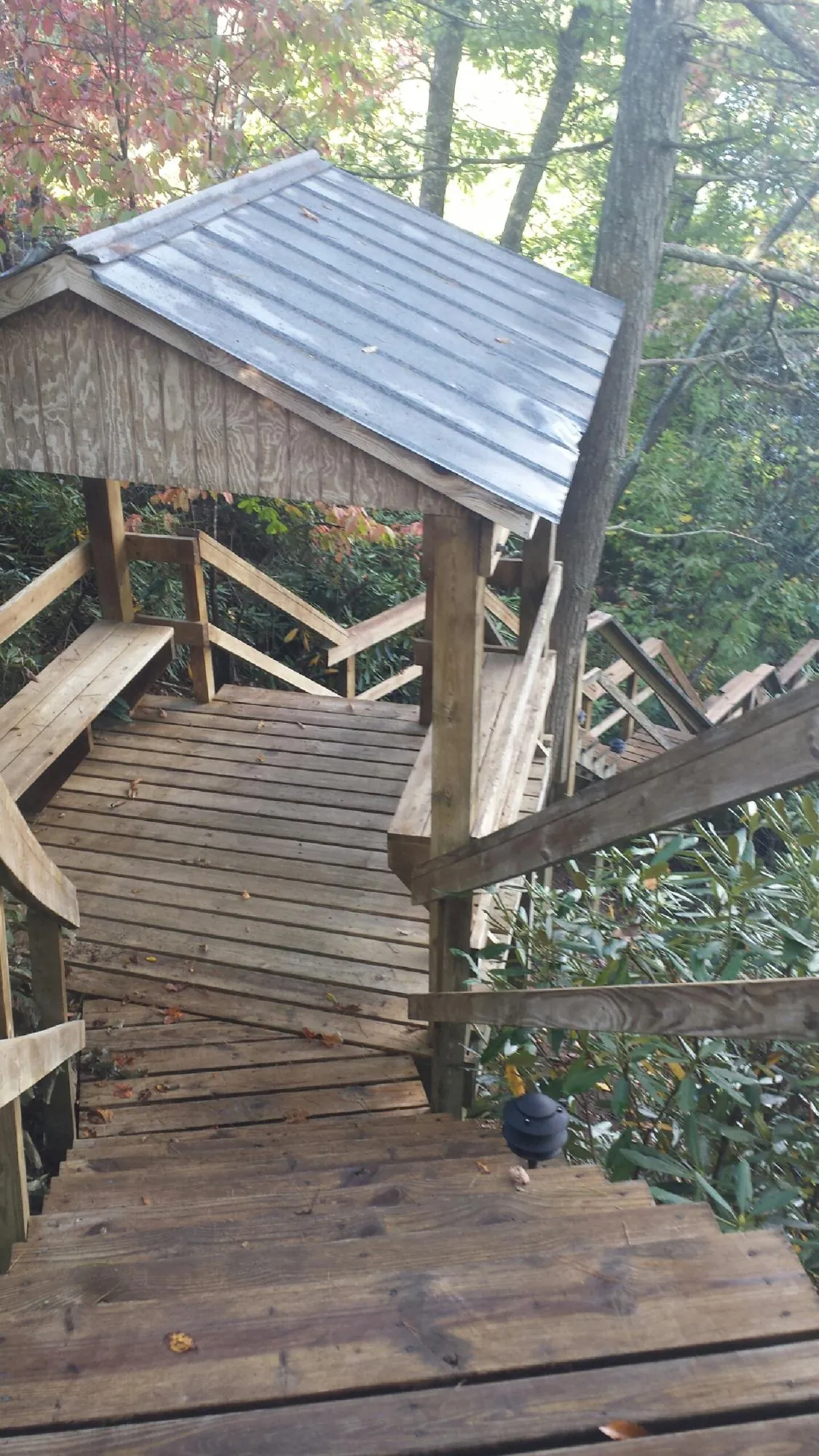 Metal roofed shelter over wooden steps on a wooded walkway — Skylight Repair & Installation work by our crew in Imperial